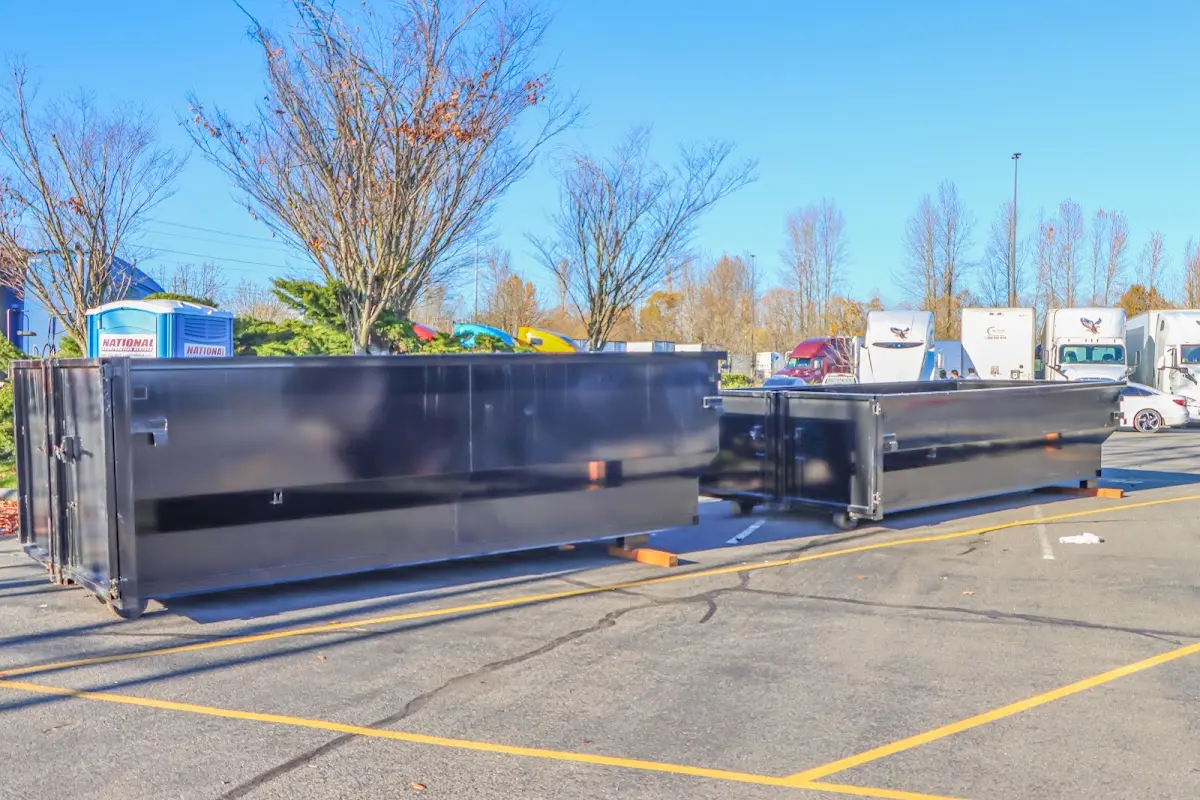 Professional dumpster rental service with roll-off container on residential driveway in Riverhead